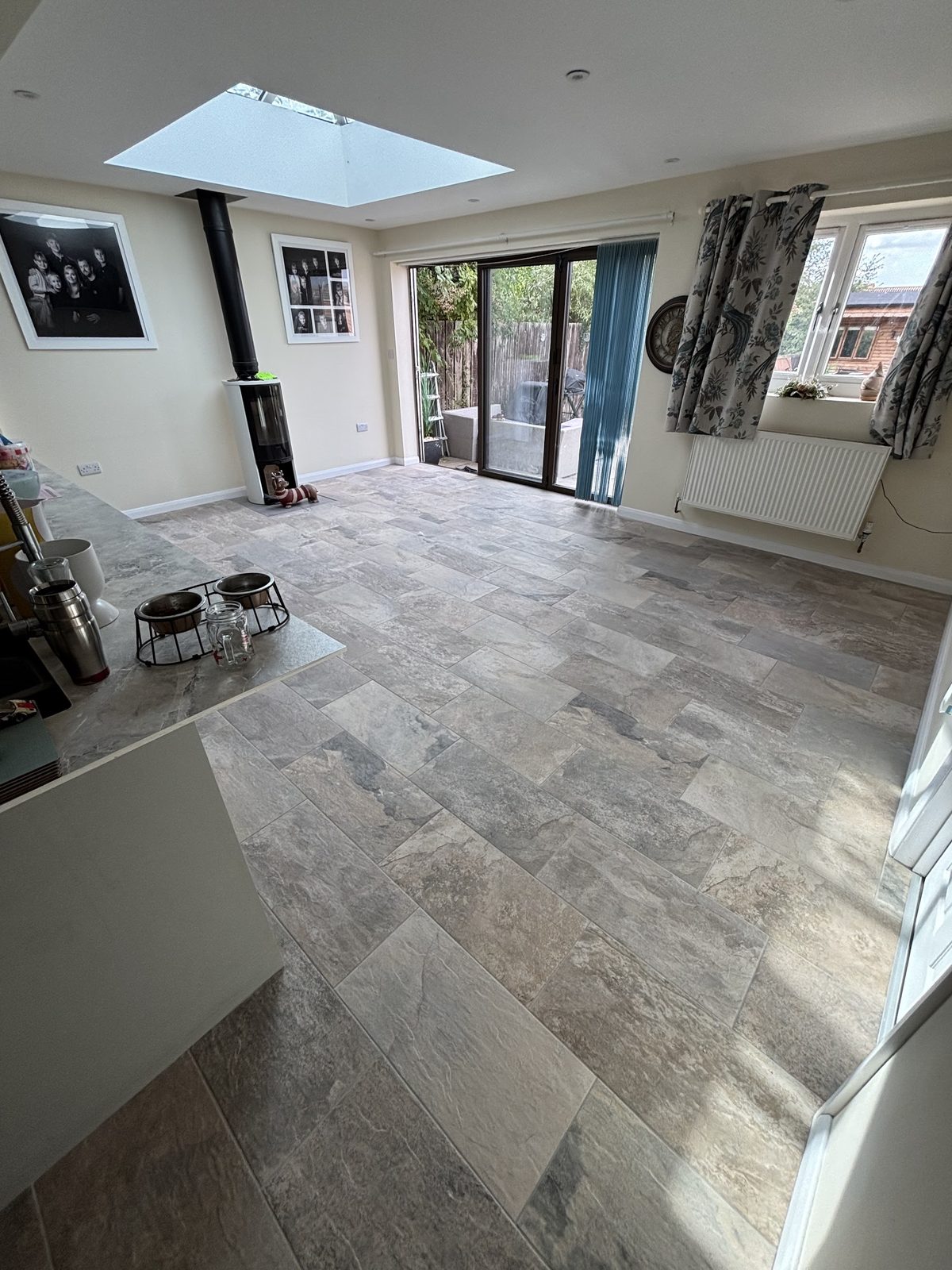 Stone-effect floor tiles running through an open-plan kitchen and living room