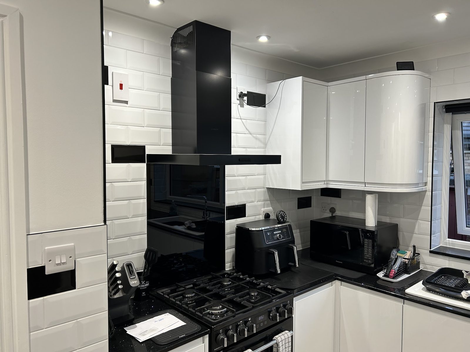 Kitchen with white metro wall tiles around the hob and worktops